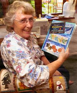 Mary Mayne holding a copy of her book